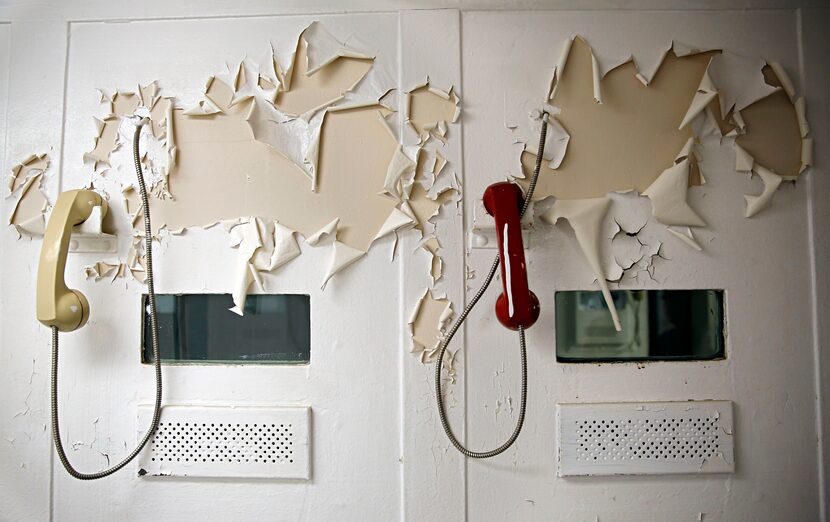 Paint peels over visitation phones in a decommissioned jail inside the old Dallas County...