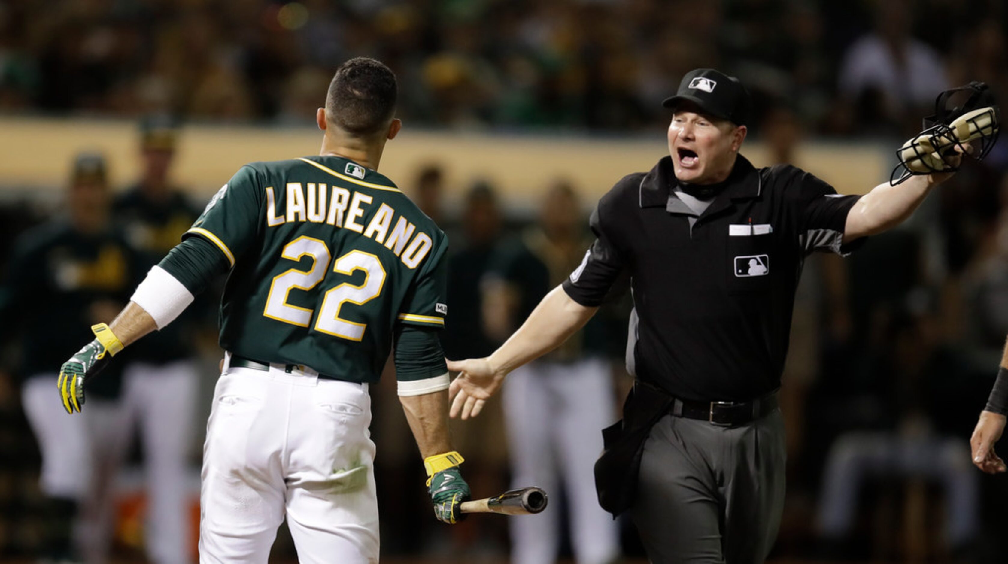 Oakland Athletics' Ramon Laureano, left, reacts after being hit by a pitch thrown by Texas...