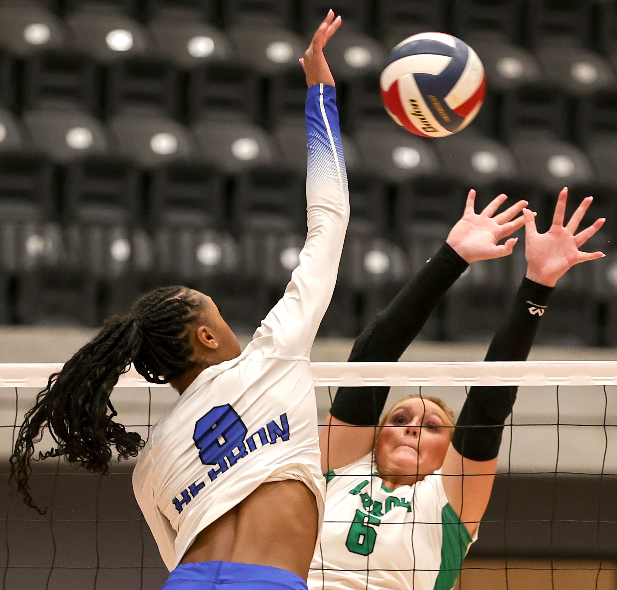 Hebron's Taylor Johnson (8) attempts a kill against Southlake Carroll's Mary Beth Morse (6)...