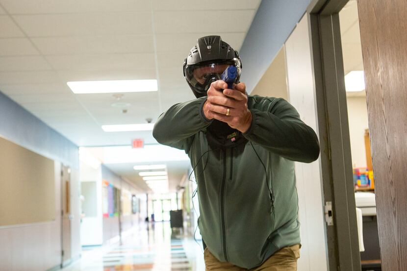 A Texas school employee training to become an armed school marshal steps into the hallway...