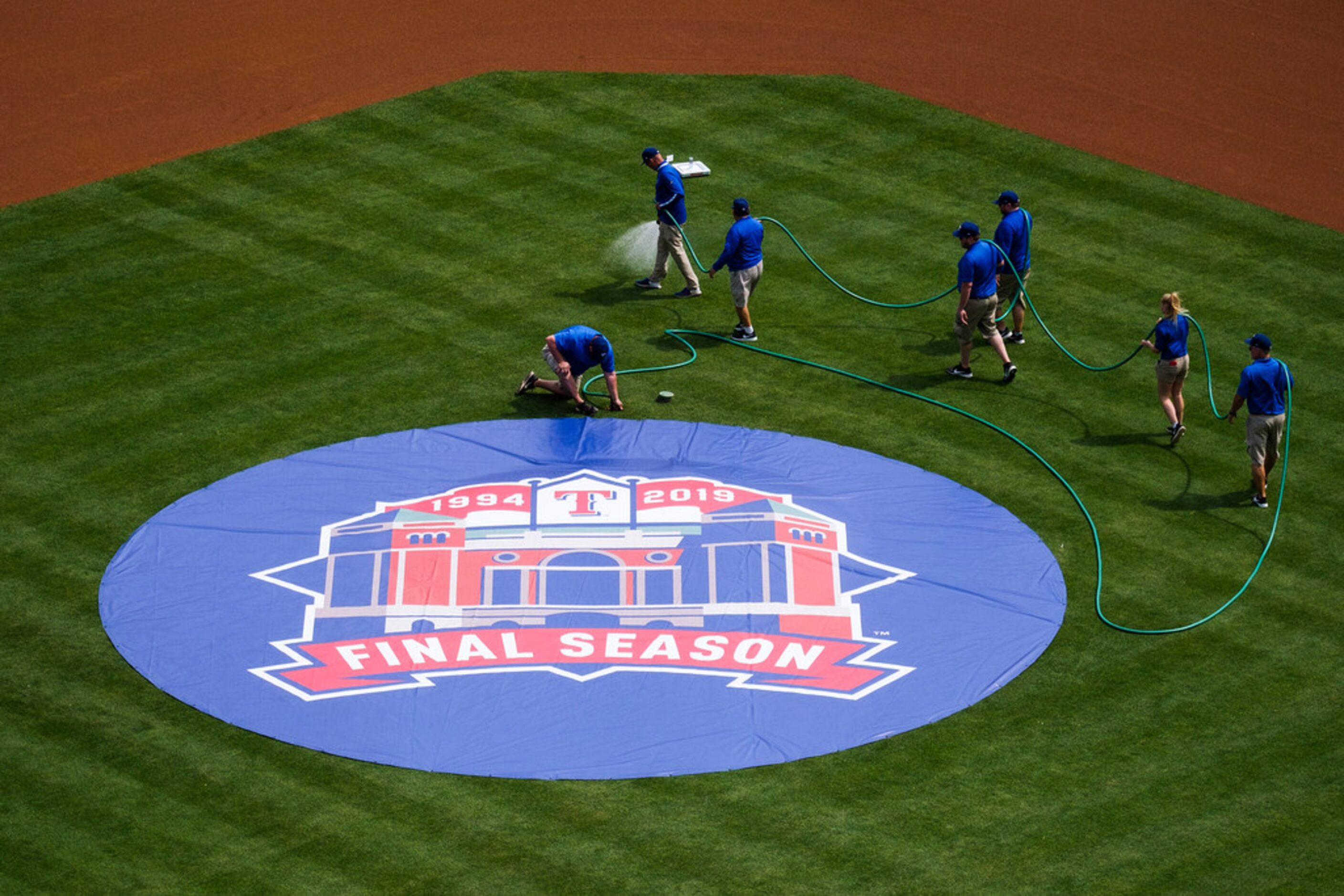 Groundskeepers preparer the field before the Texas Rangers opening day game against the...