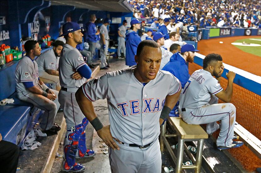  October 14, 2015--Texas Rangers third baseman Adrian Beltre, center, stands in the dugout...