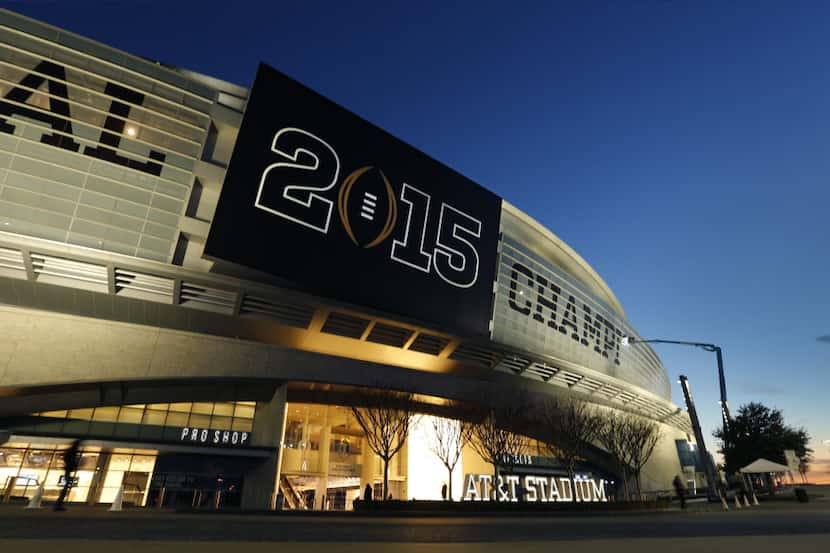 Crews install the College Football Playoff National Championship lettering on the exterior...