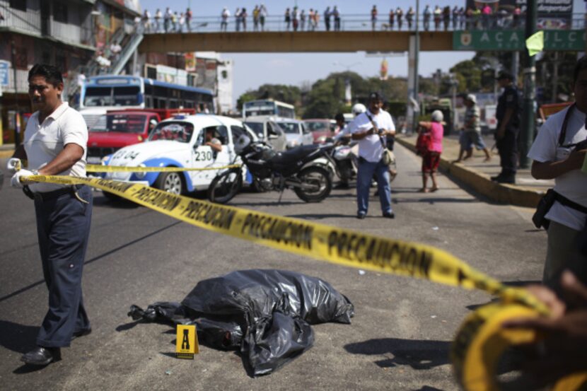 Police officers secure the area where human remains inside a plastic bag were dumped on a...