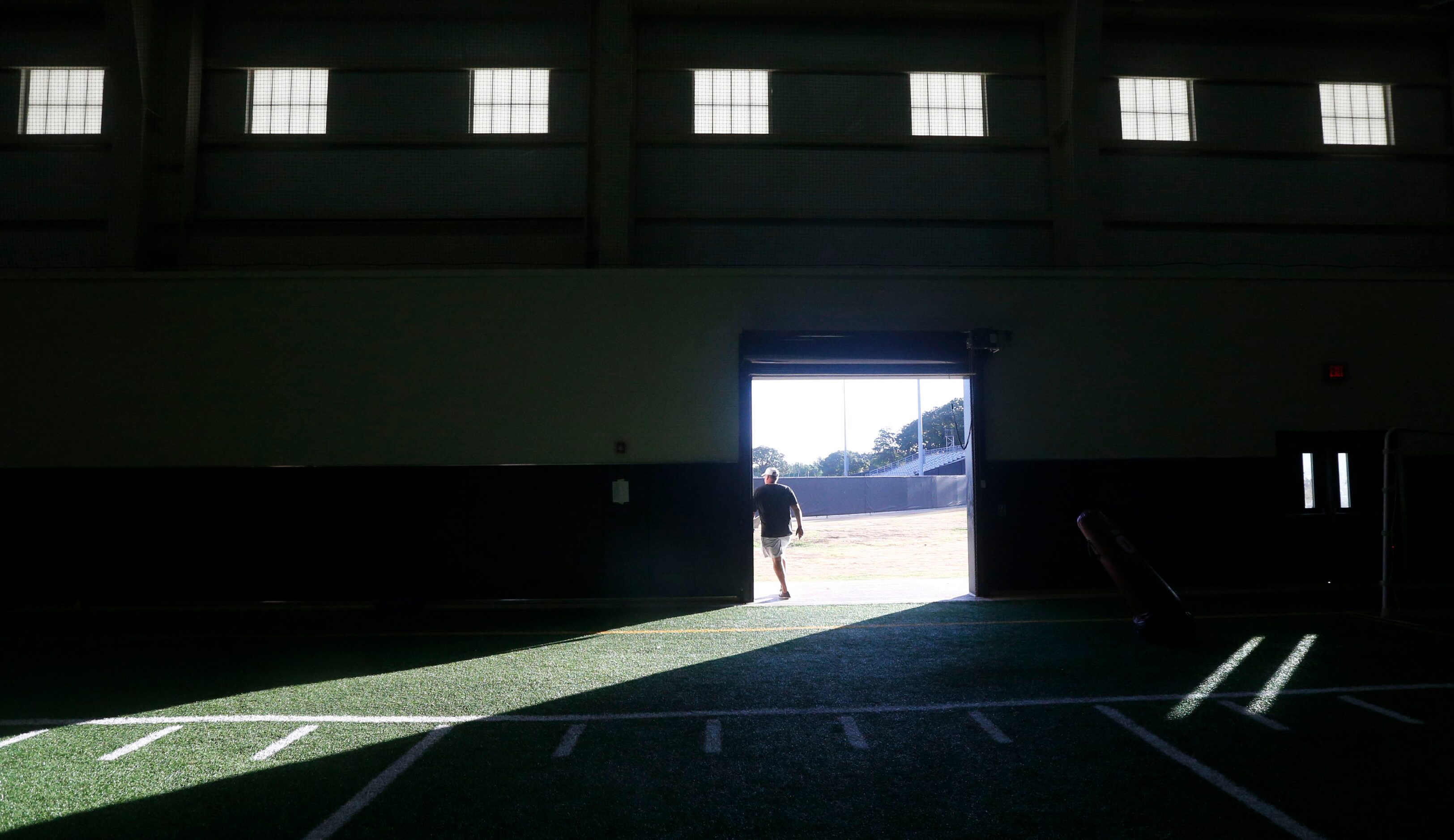 Coach Chris Jensen walks from the practice facility to the field during Euless Trinity's...