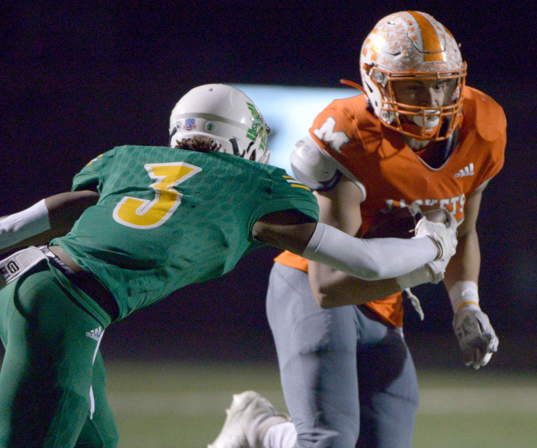 Mineola’s Kobe Kenrick (24) tries to run through a tackle by Madison’s Tristin Rodgers in...