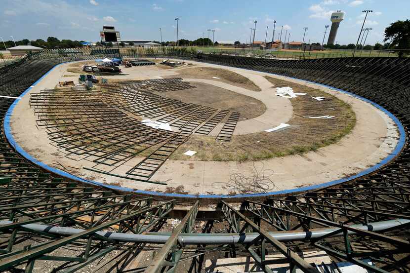 Volunteers are dismantling the supports of the Frisco Superdrome, a cycle-racing track with...