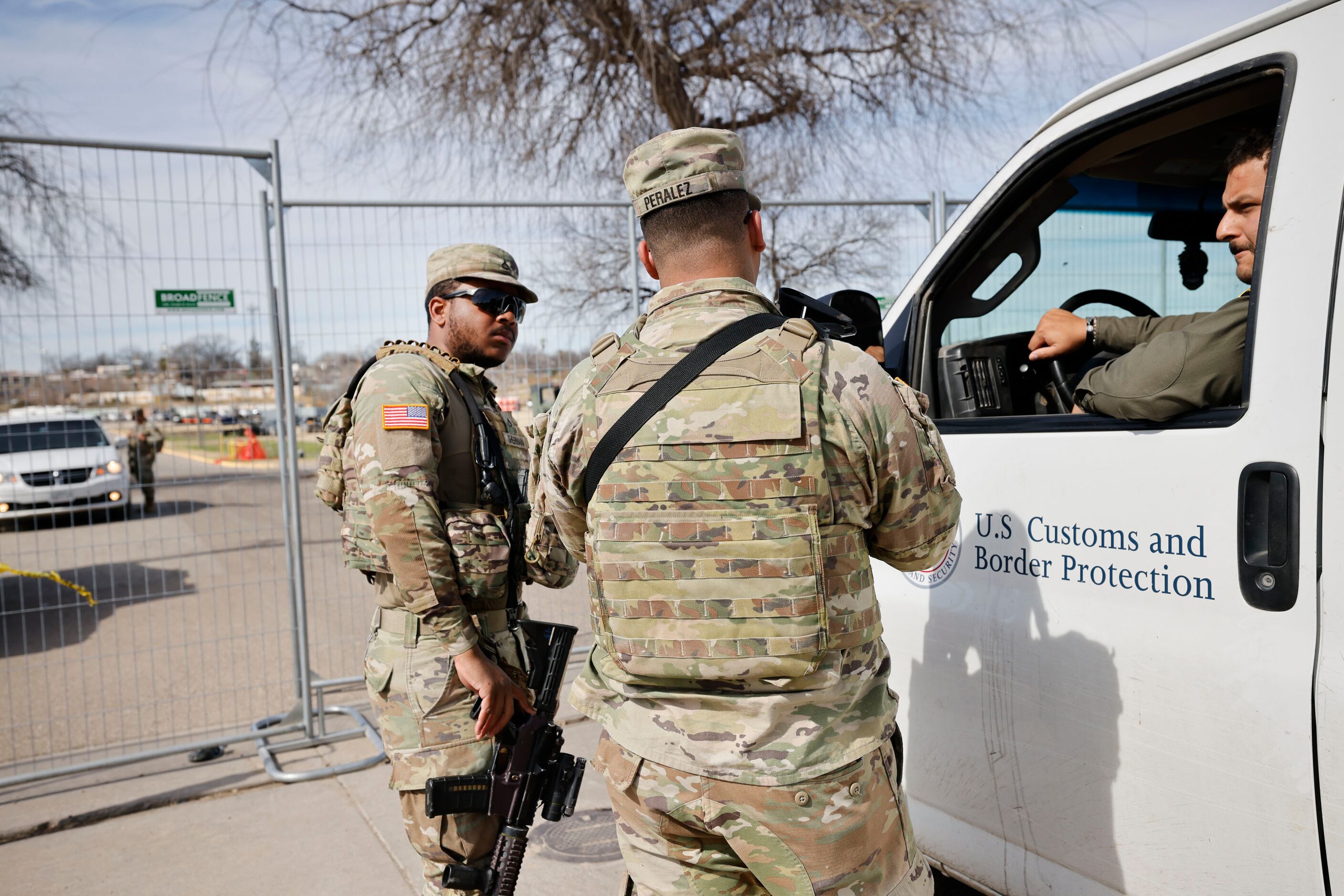 Texas National Guard soldiers talk with Border Patrol agents in front of the gate at Shelby...