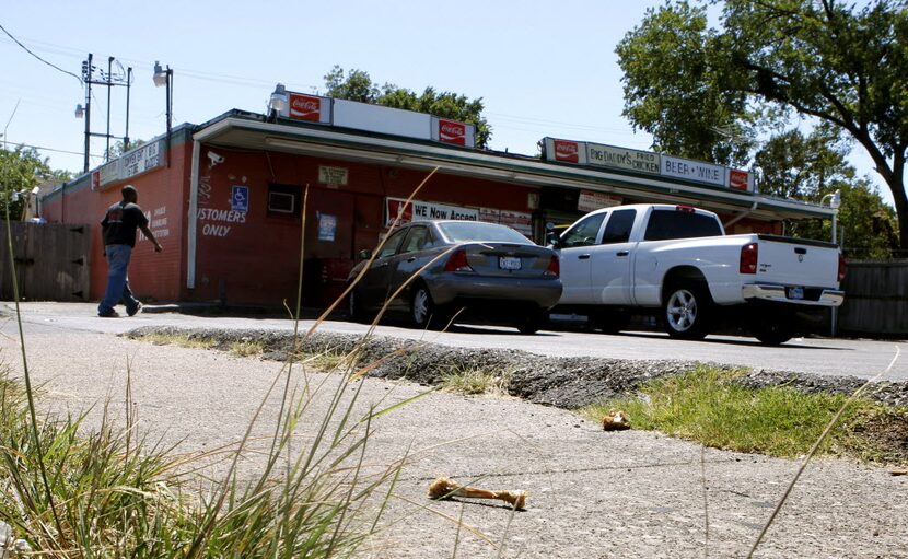 Chicken bones from Big Daddy's fried chicken lay on the sidewalk in front of the convenience...