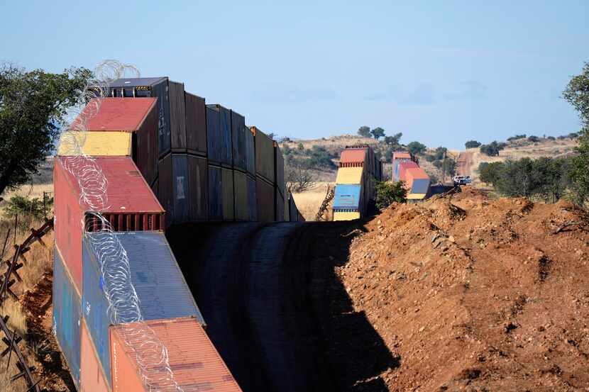 Una hilera de contenedores de carga apilados en la frontera entre Estados Unidos y México,...