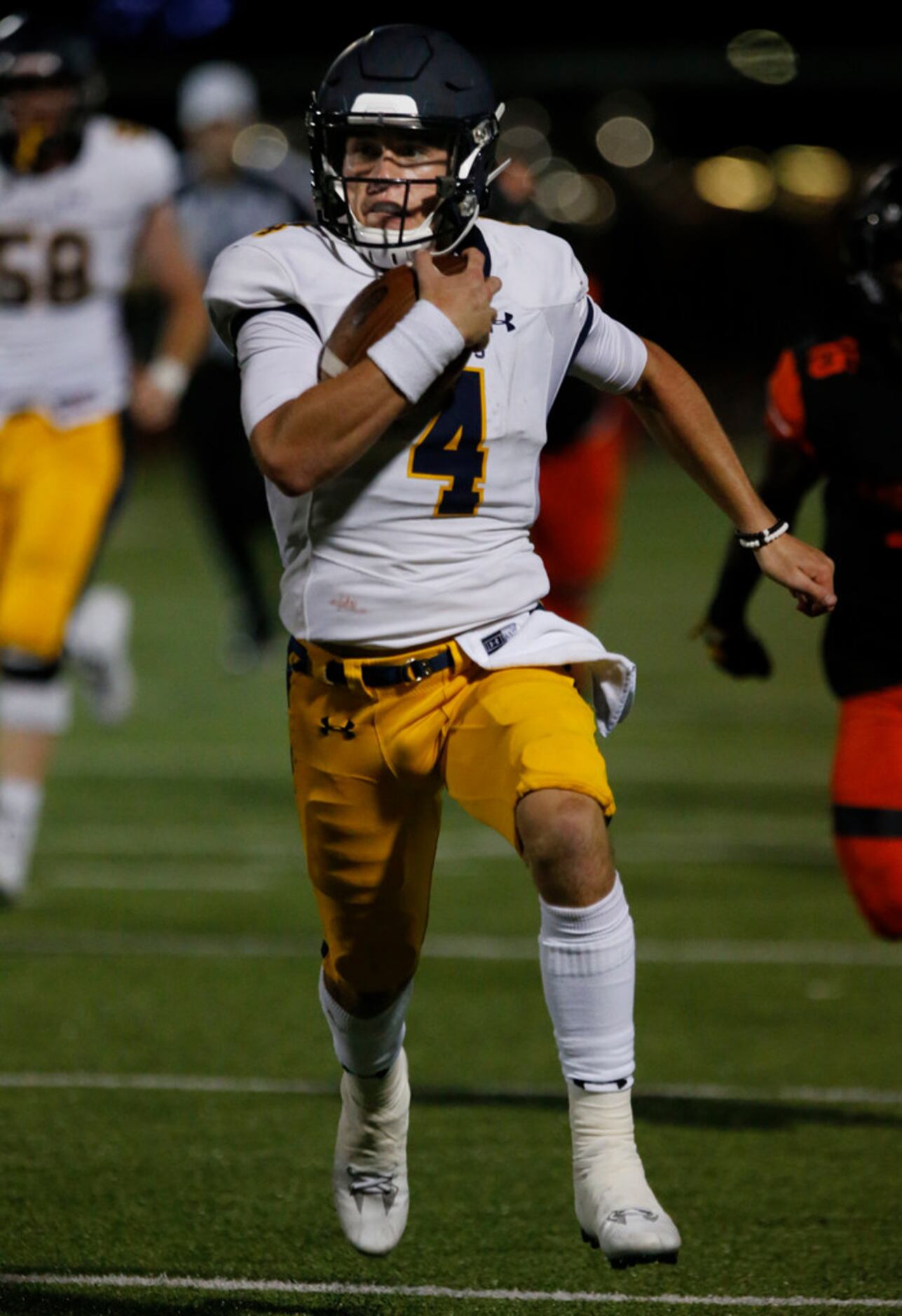 Highland Park quarterback (4) breaks loose on a touchdown run during the first half of a...
