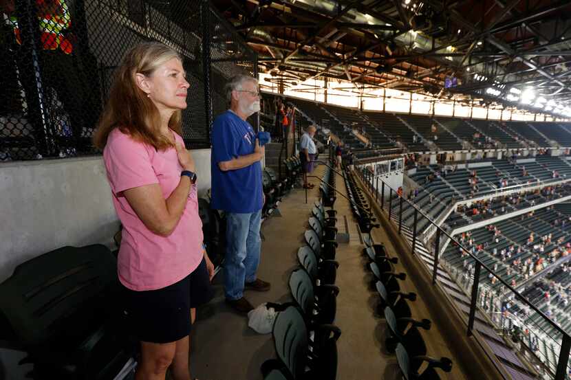 Season ticket holder Pam Lunk of Arlington, and Bob Brewton, of Lewisville, right, stand for...