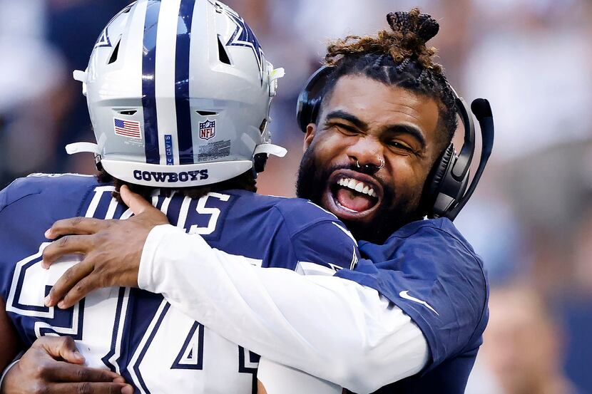 Injured Dallas Cowboys running back Ezekiel Elliott (right) hugs fellow running back Malik...
