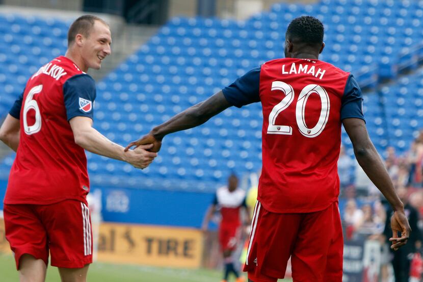 FC Dallas' Roland Lamah (20) receives congratulations from teammate Anton Nedyalkov (6)...