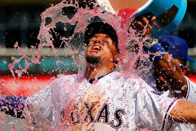 Texas Rangers left fielder Carlos Gomez relishes the sports drink dump by teammate Elvis...