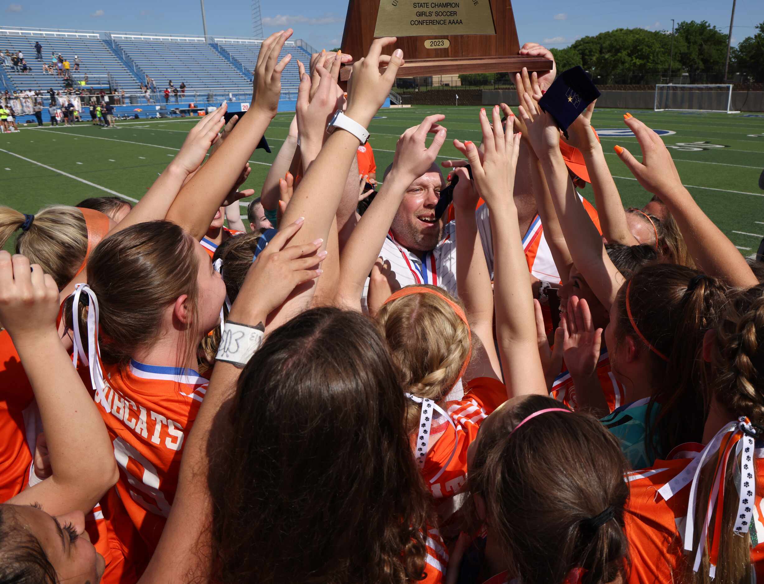 Celina head coach Alexander Adams raises the state championship trophy as he celebrates with...