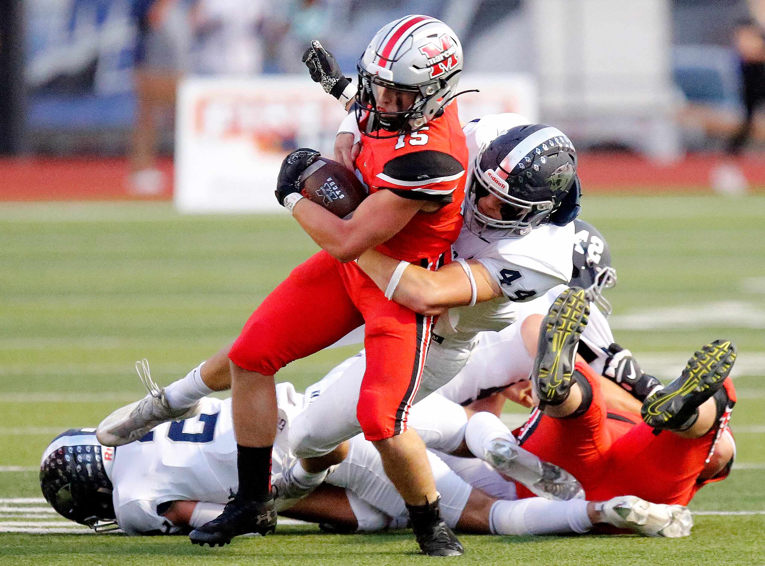 Flower Mound Marcus High School running back Gabe Espinoza (15) is brought down by Flower...