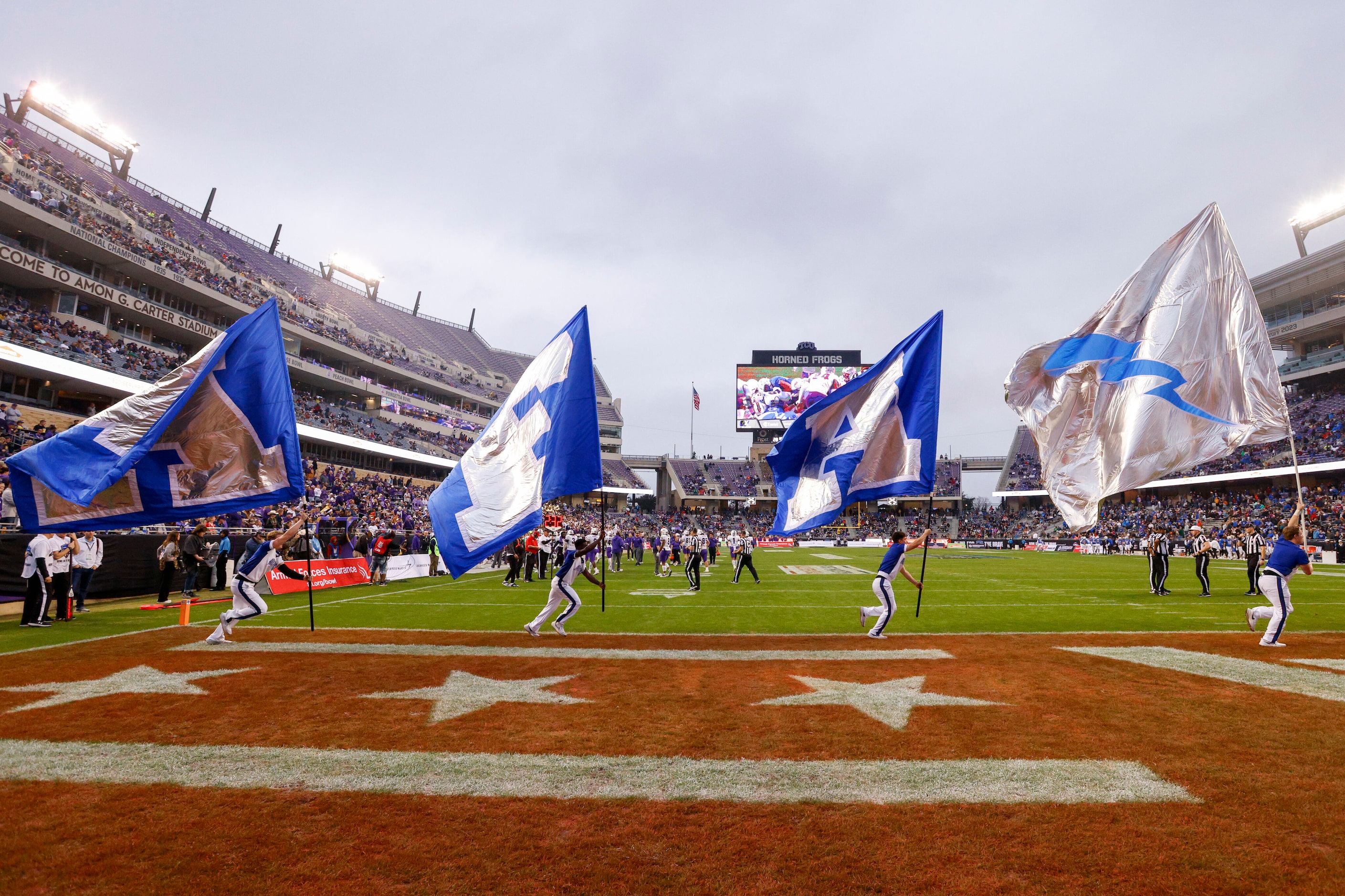 Air Force cheerleaders run with flags after a field goal during the second half of the Armed...