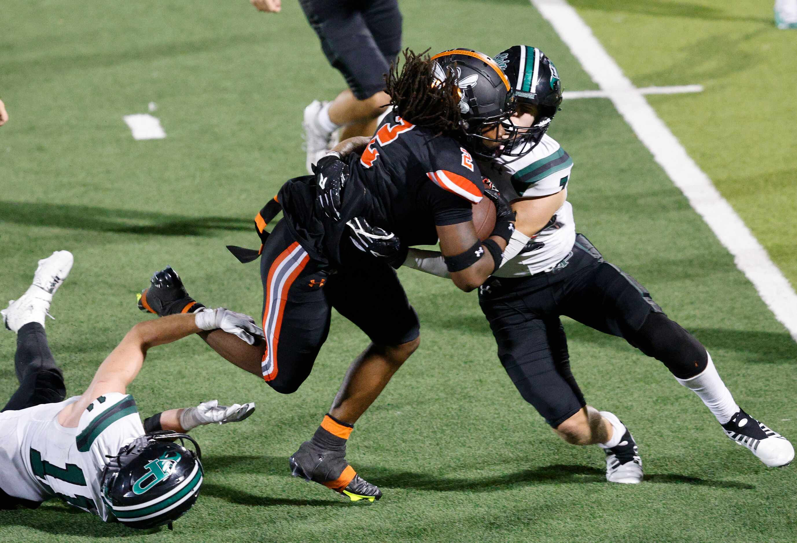 Rockwall's Ashten Emory (2), center, is tackled by Prosper's Andrew Ward (7) , right, during...