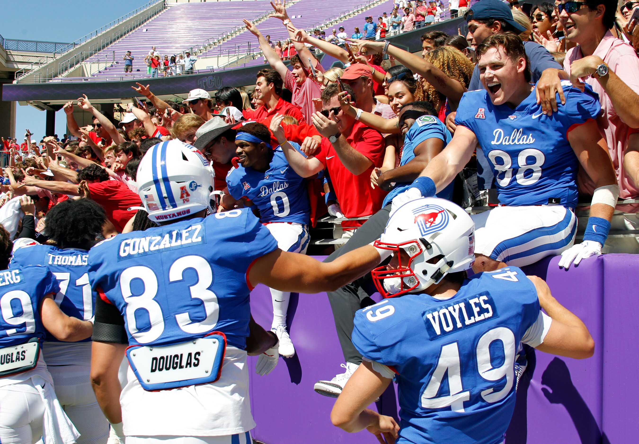 SMU Mustangs players celebrate with fans following their 42-34 victory over TCU. The two...