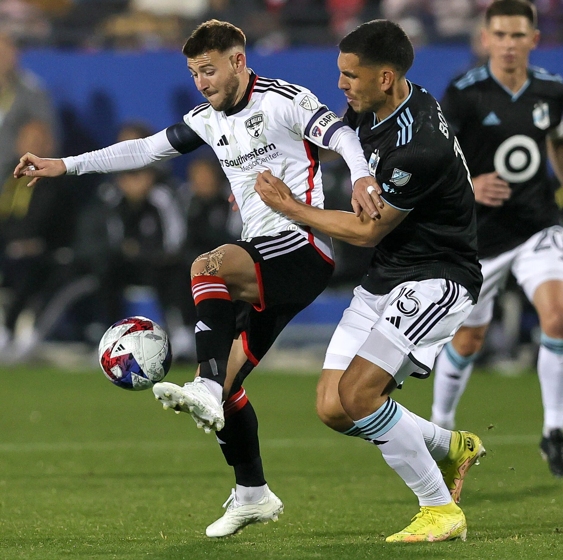 FC Dallas attacker Paul Arriola, (left) tries to control the ball from Minnesota United...