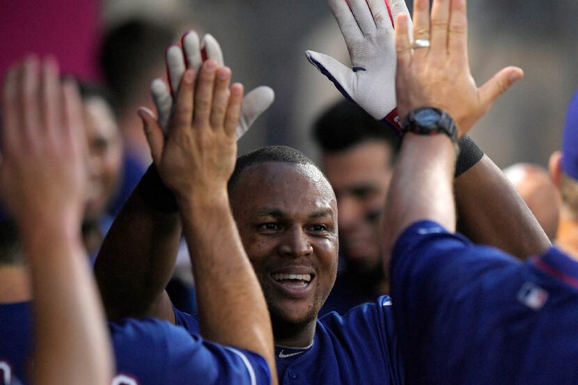 Texas Rangers' Adrian Beltre is congratulated by teammates after hitting a solo home run...