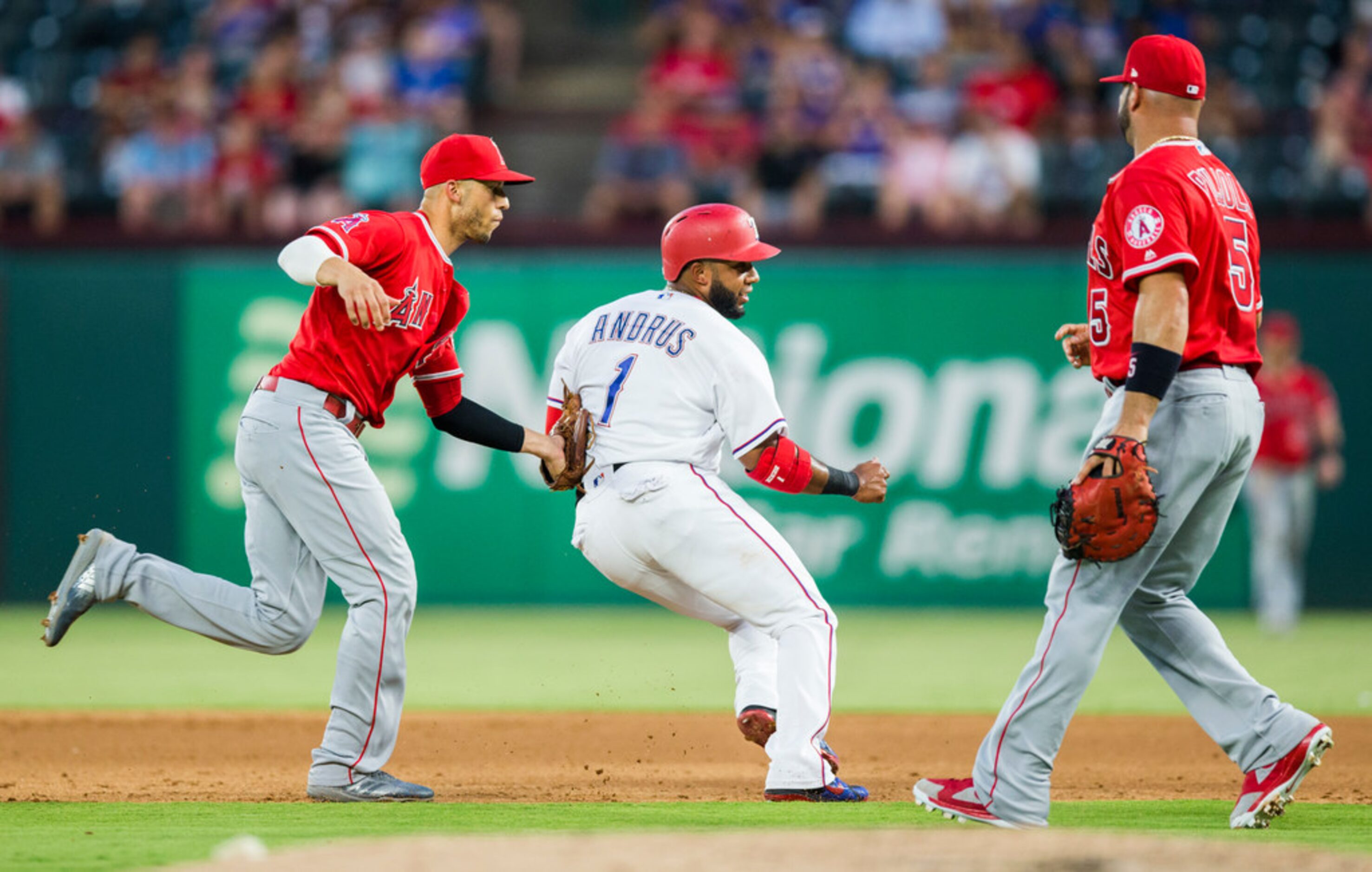 Texas Rangers shortstop Elvis Andrus (1) is tagged out between first and second base by Los...