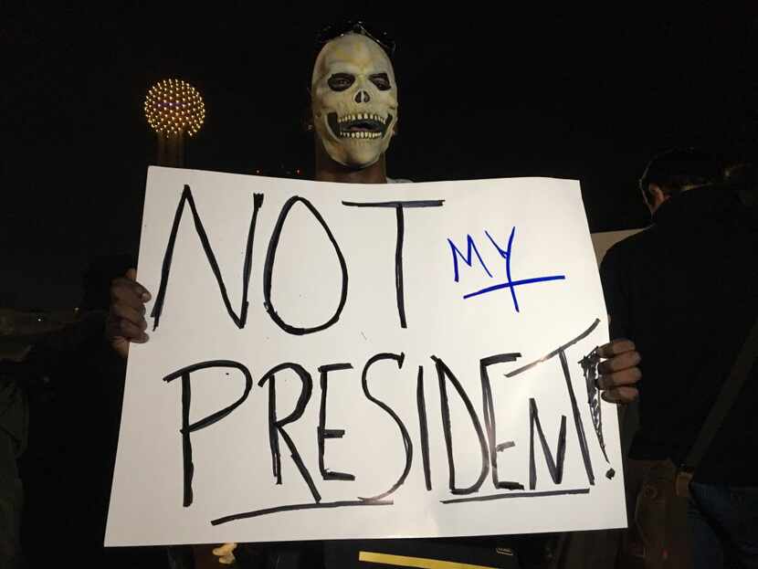 R.J. Nichols, a protester against President-elect Donald Trump, holds up a sign during a...