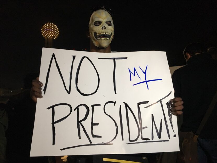 R.J. Nichols, a protester against President-elect Donald Trump, holds up a sign during a...