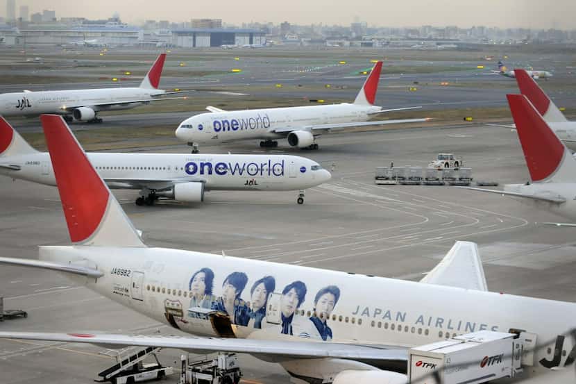 Japan Airlines jets jam the tarmac at Tokyo Haneda Airport. American Airlines and its...