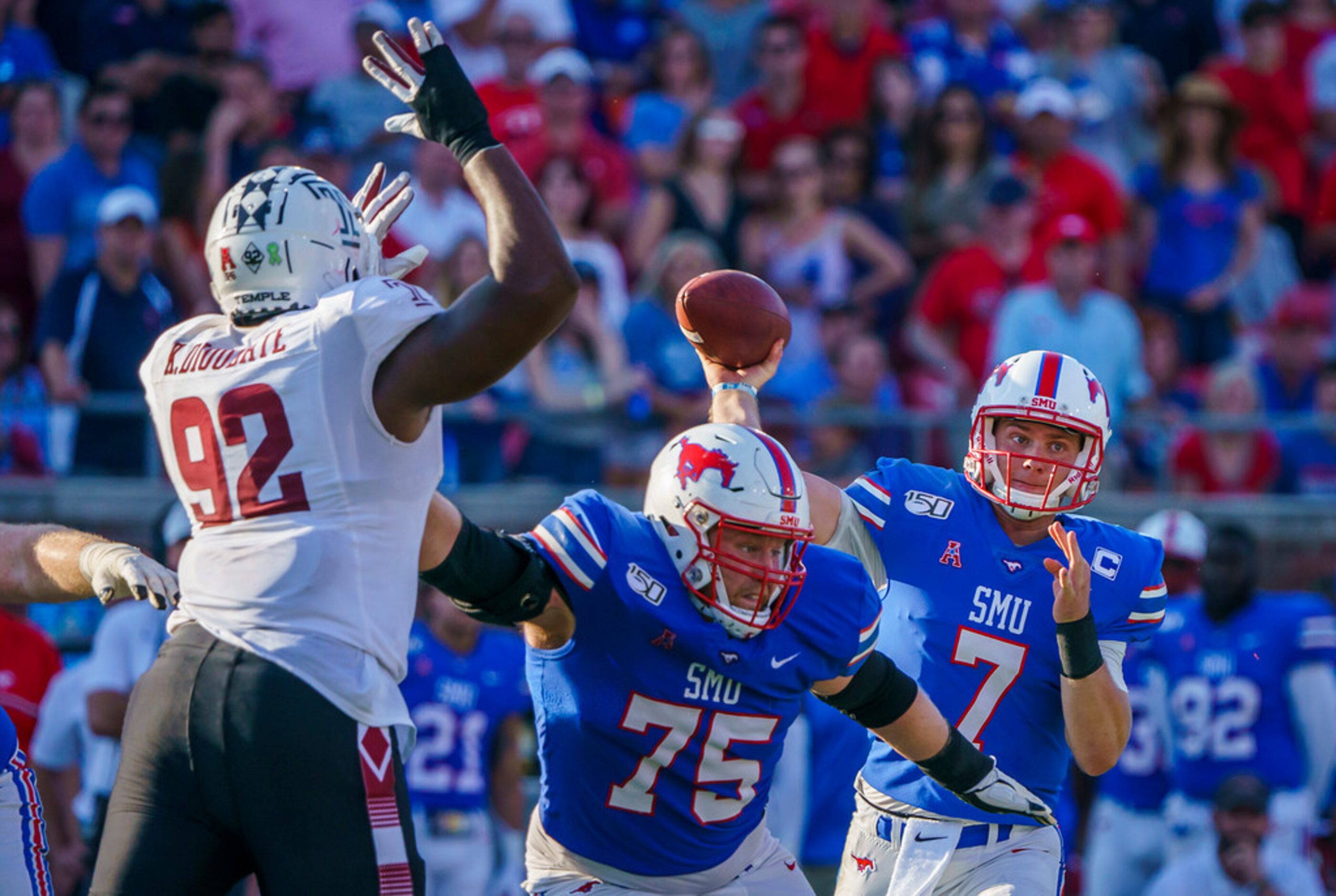 SMU quarterback Shane Buechele (7) gets a block from offensive lineman Hayden Howerton (75)...