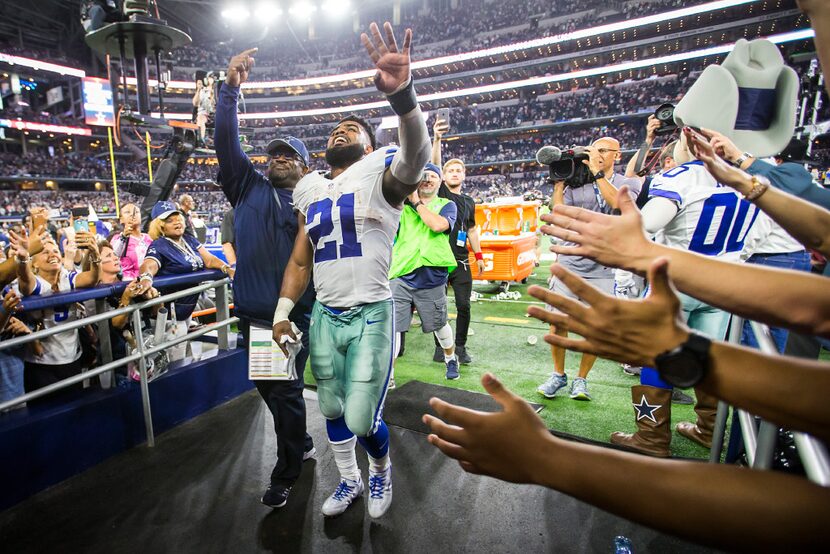 Dallas Cowboys running back Ezekiel Elliott waves to the crowd as he leaves the field after...