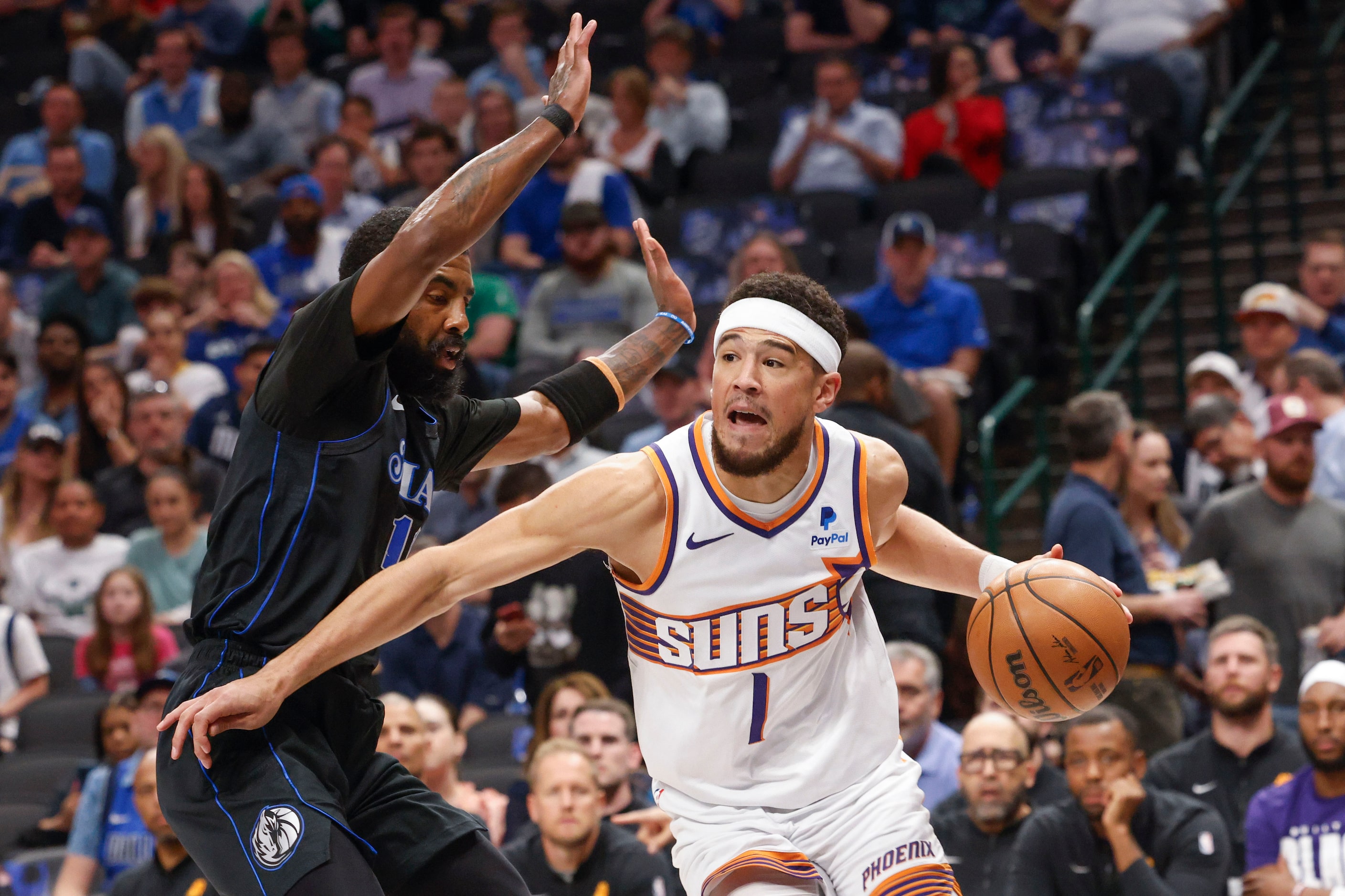 Dallas Mavericks guard Kyrie Irving (left) defends against Phoenix Suns guard Devin Booker...