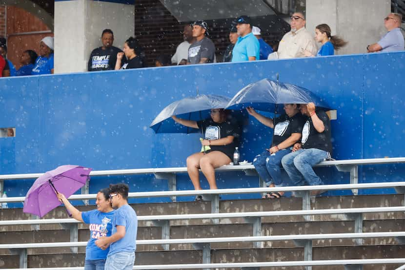 Crowd take shelter from rain during a rain delay of a season-opening football game between...