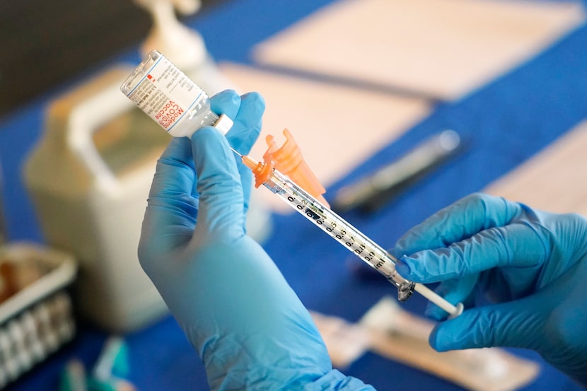 FILE - A nurse prepares a syringe of a COVID-19 vaccine at an inoculation station in...