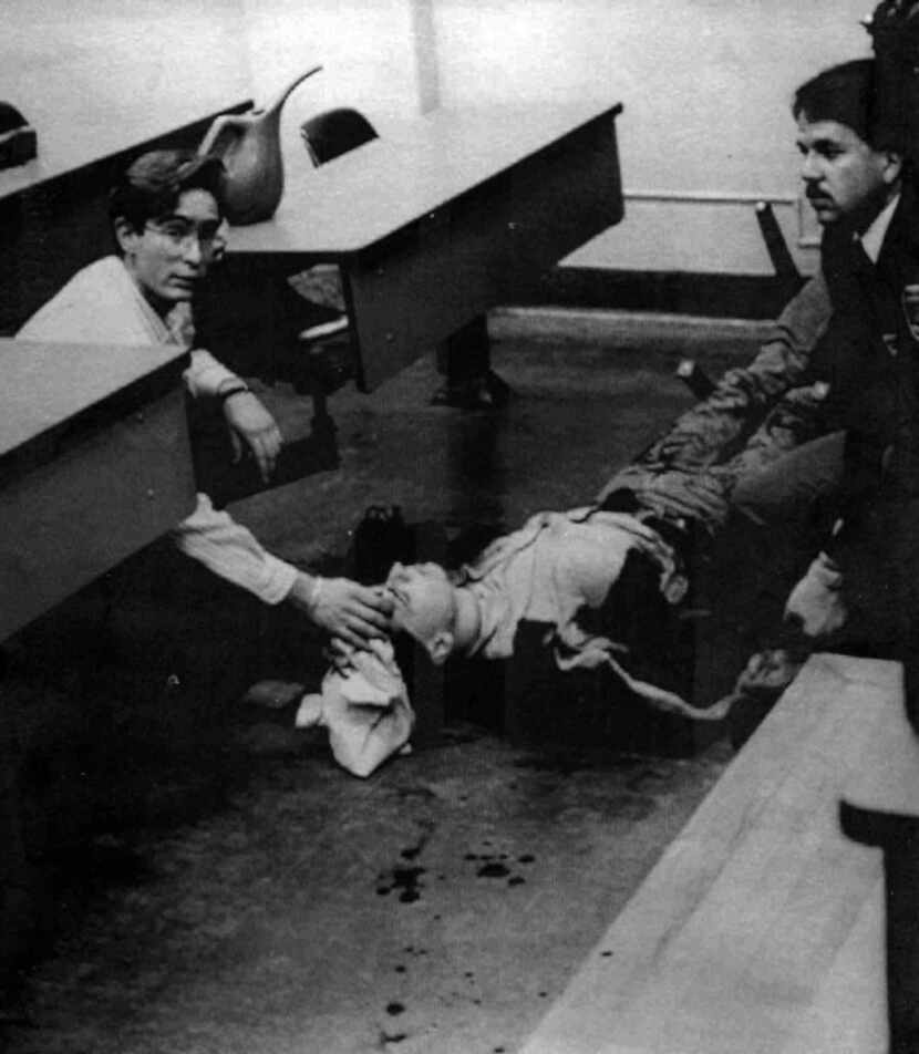 An unidentified person attends to a wounded woman on Dec. 6, 1989, at Montreal's Ecole...