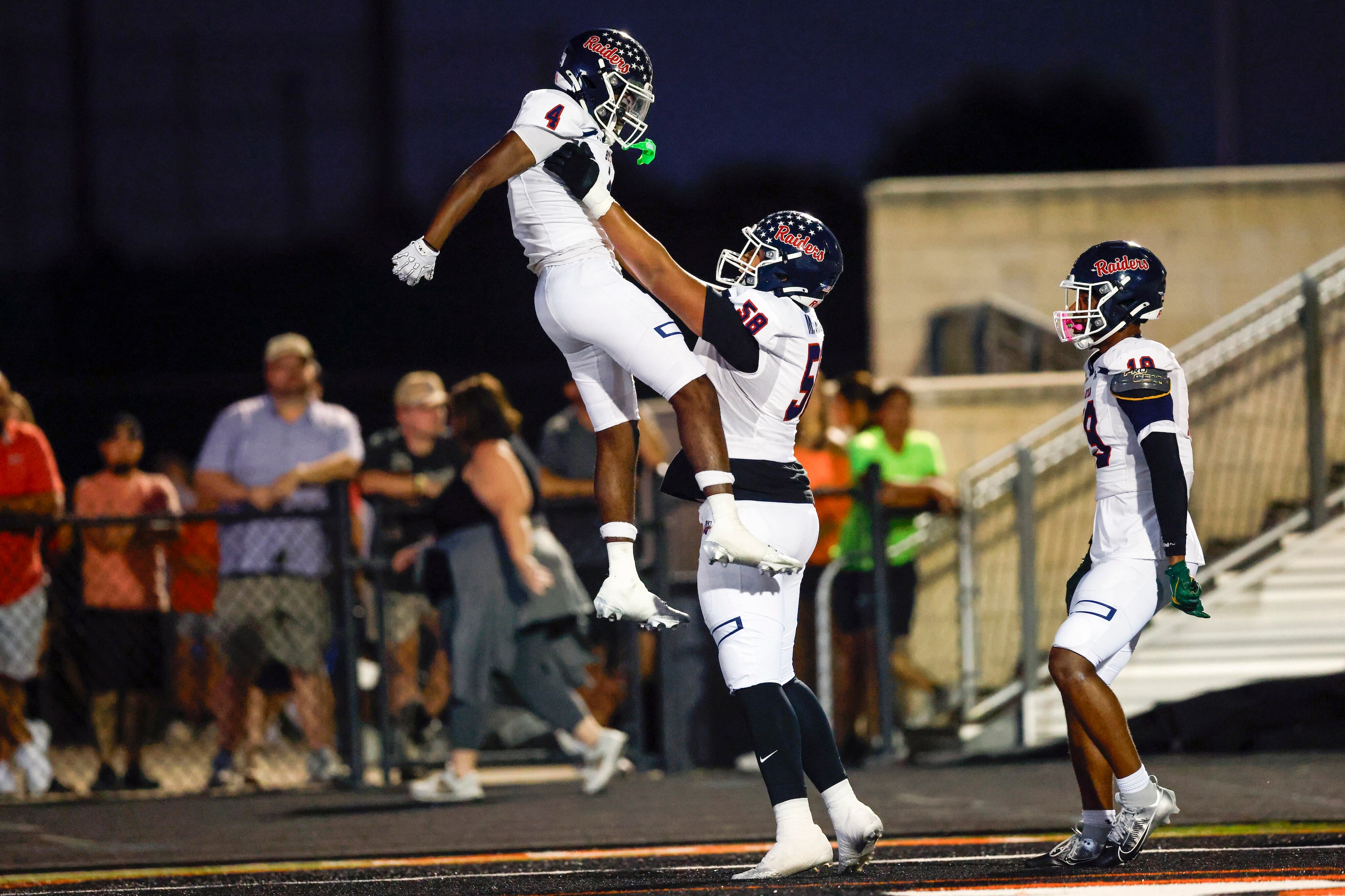 Denton Ryan offensive lineman Marcus Garcia (58) lifts Denton Ryan running back Tre'Vaughn...