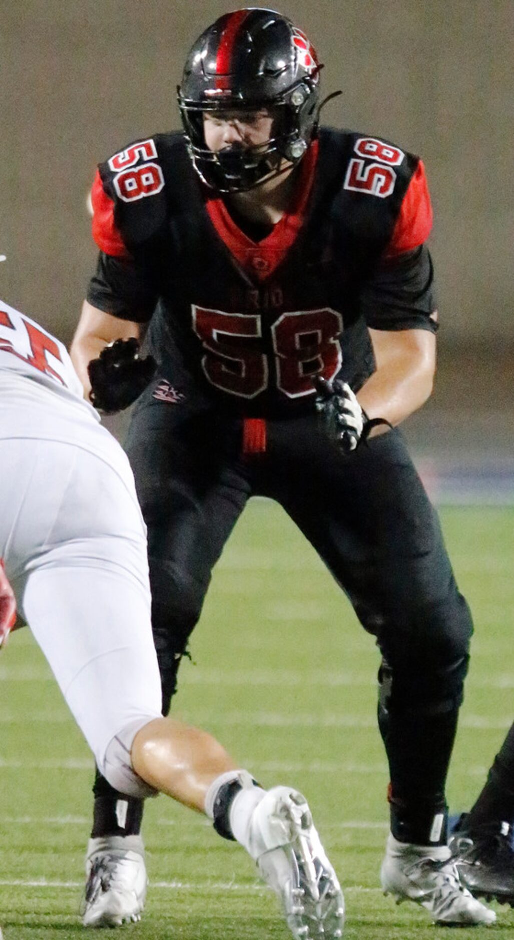 Colleyville Heritage High School offensive lineman Gavin Byers (58) rises up to block during...