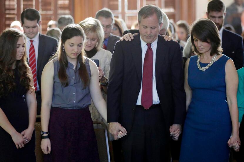 
Ken Paxton joins hands with family members during a prayer after he was sworn in as the...