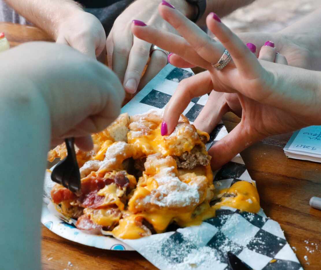 Sarah Blaskovich, right, of The Dallas Morning News GuideLive team samples the Funnel Cake...