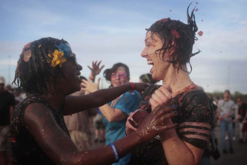Shanita Mims embraces her friend Ladessa Jones during a tomato battle at theTexas State...