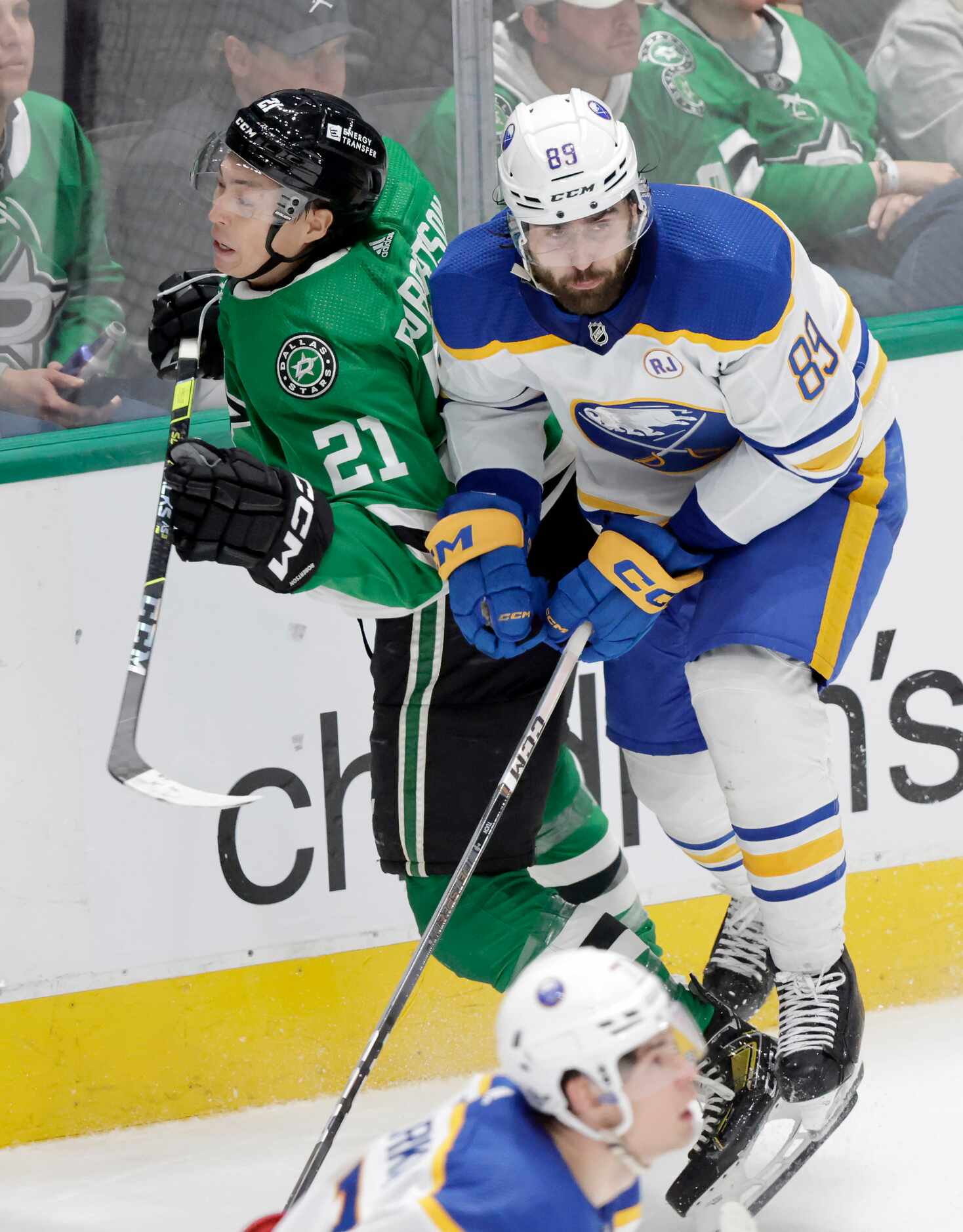 Dallas Stars left wing Jason Robertson (21) is checked in the back by Buffalo Sabres right...