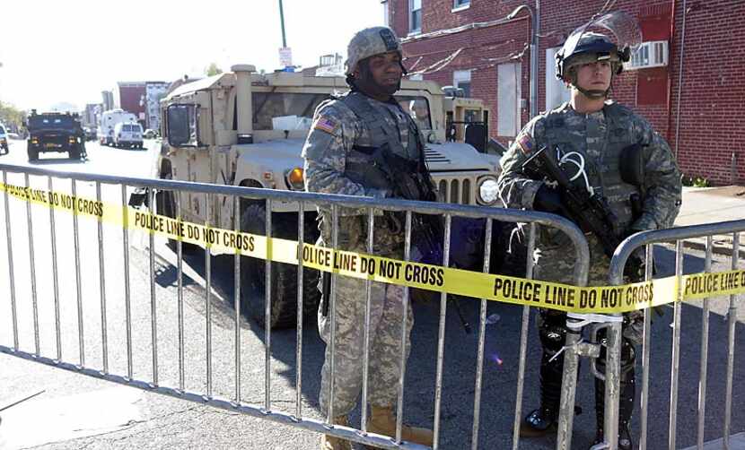 National Guardsmen stand watch at a checkpoint Tuesday in Baltimore, where Maryland Governor...