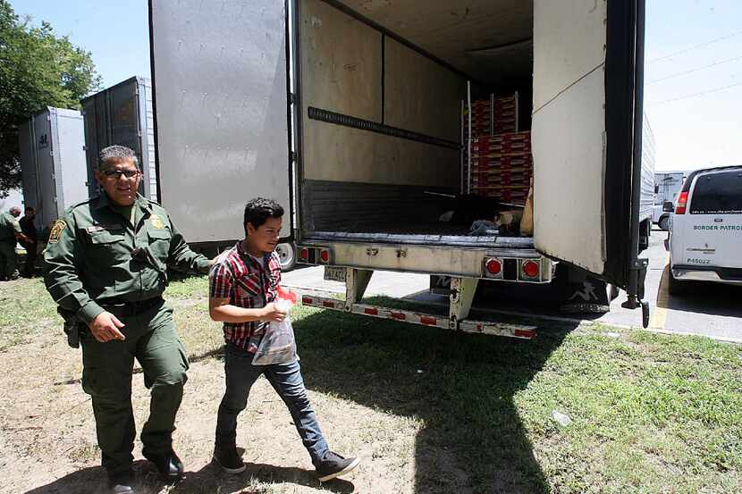 In this Sunday, Aug. 13, 2017, photo, Border Patrol officers escort a group of immigrants to...