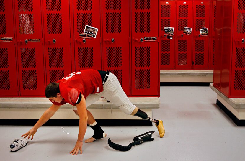 Steele Downing, a 16-year-old junior at Lovejoy High School, reaches for a shoe as he...