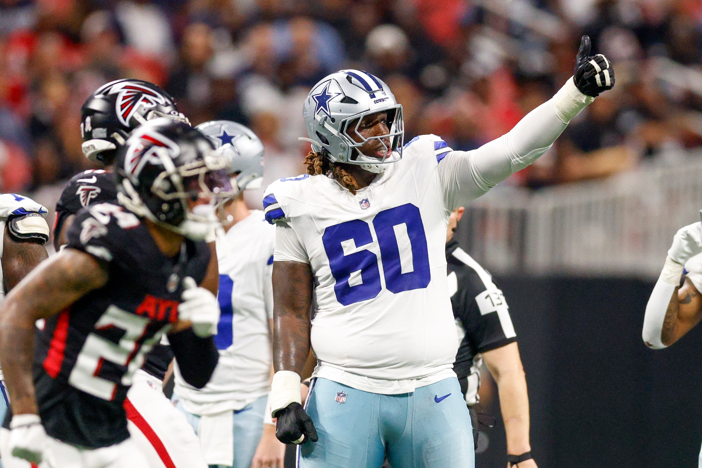 Dallas Cowboys offensive tackle Tyler Guyton (60) signals to the sideline during the second...