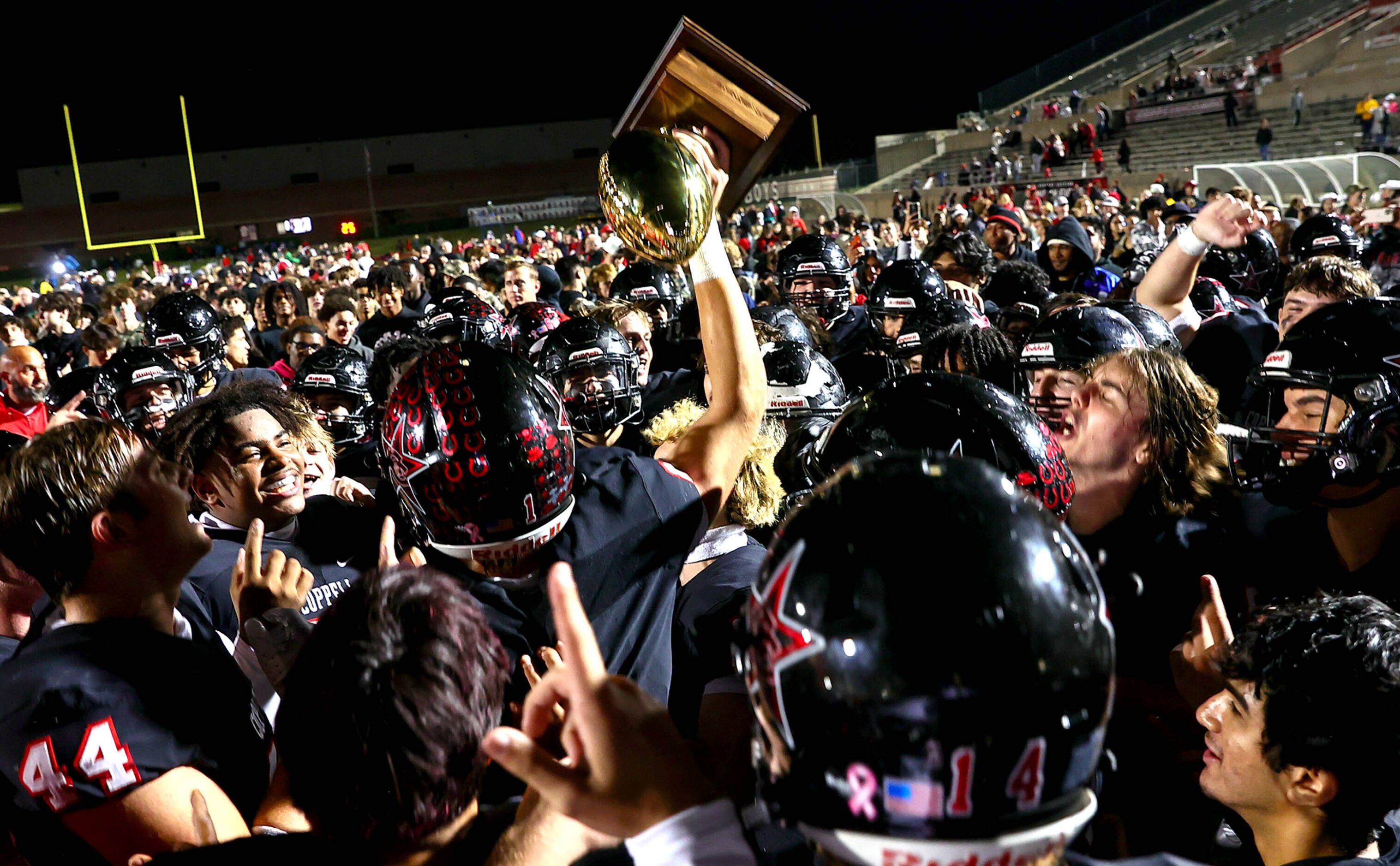 The Coppell Cowboys hold up the trophy after beating Denton Guyer, 35-21 in the Class 6A...