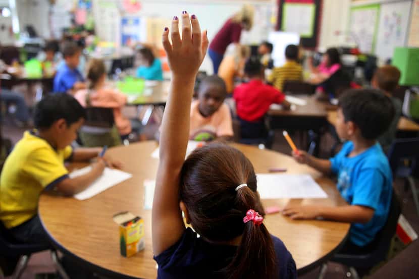 A child raises her hand at a Northrich Elementary School classroom in Richardson.