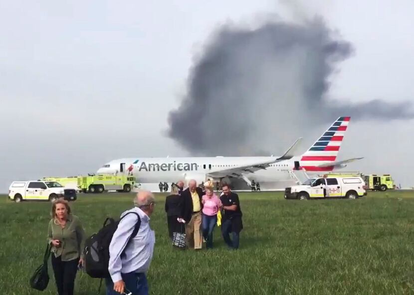 Passengers were assisted away from a burning American Airlines jet that aborted takeoff and...