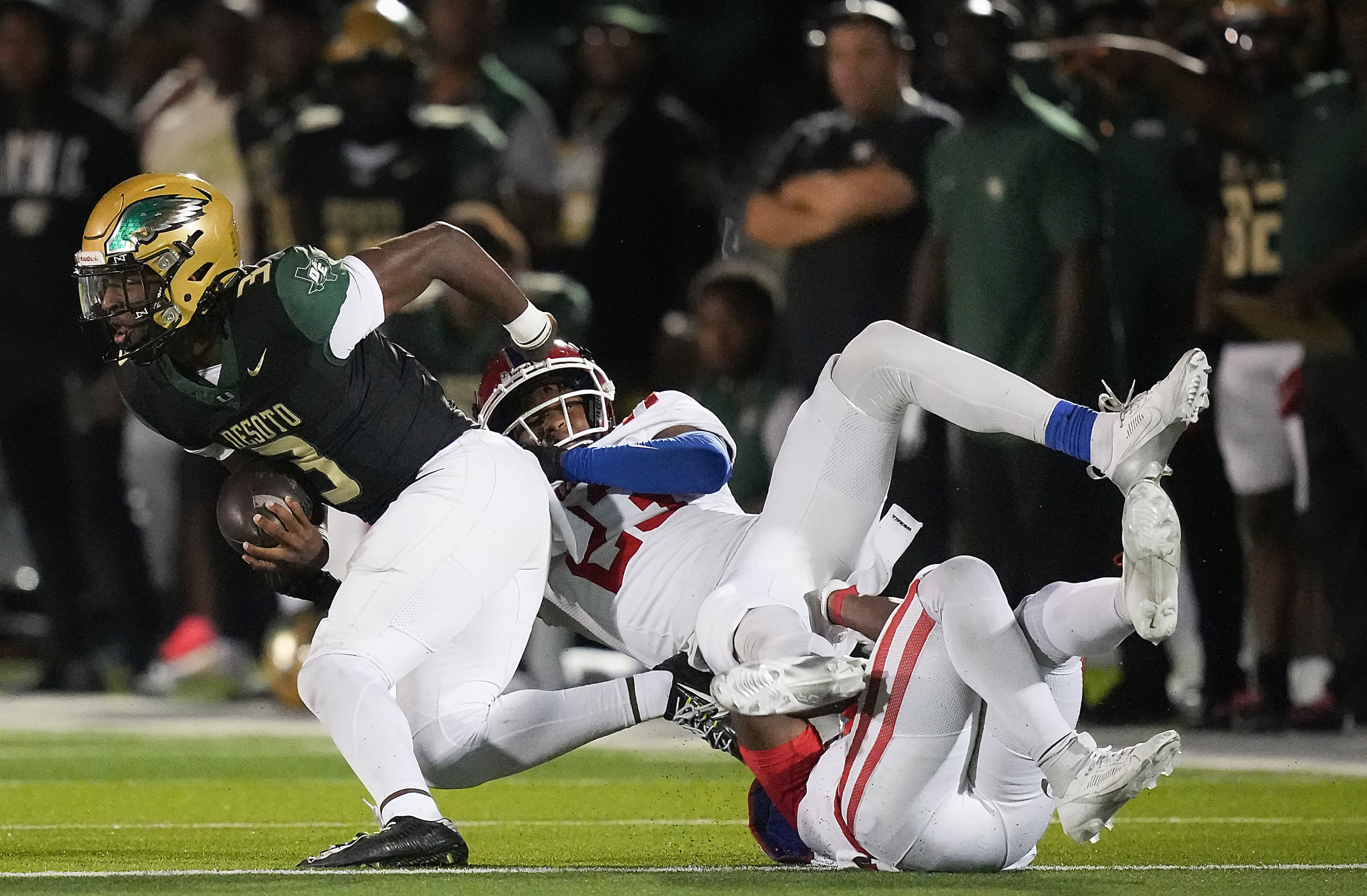 DeSoto quarterback Kelden Ryan (3) is brought down by Duncanville defensive lineman Tamir...